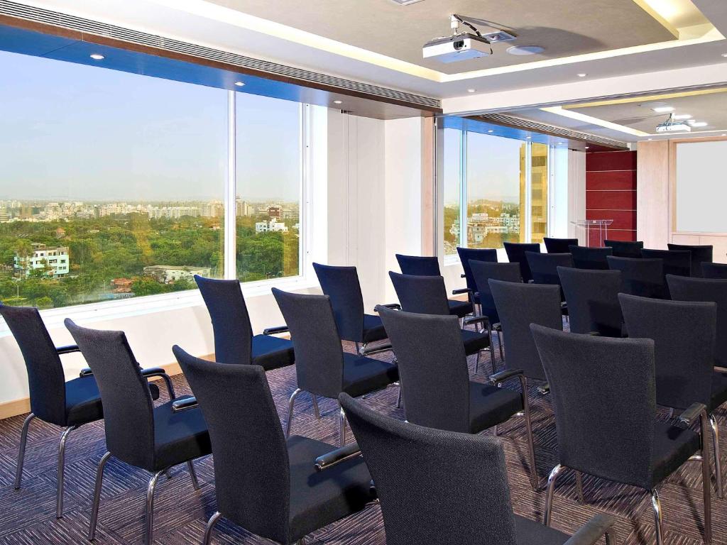 a conference room with chairs and a large window at ibis Pune Viman Nagar - An Accor Brand in Pune