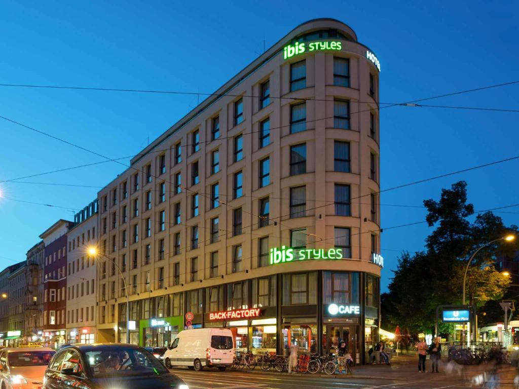 un edificio alto en una calle de la ciudad con coches en ibis Styles Hotel Berlin Mitte en Berlín