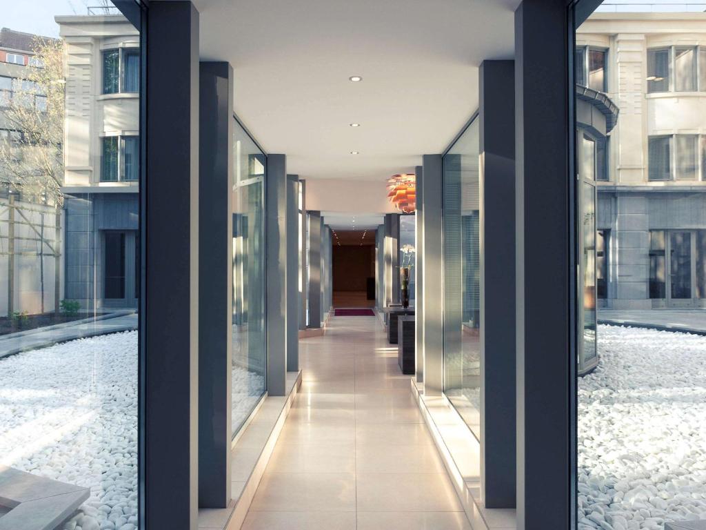 um corredor de um edifício com paredes de vidro em Mercure Hotel Brussels Centre Midi em Bruxelas
