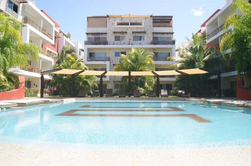 una gran piscina frente a un edificio en Sabbia Condos en Playa del Carmen