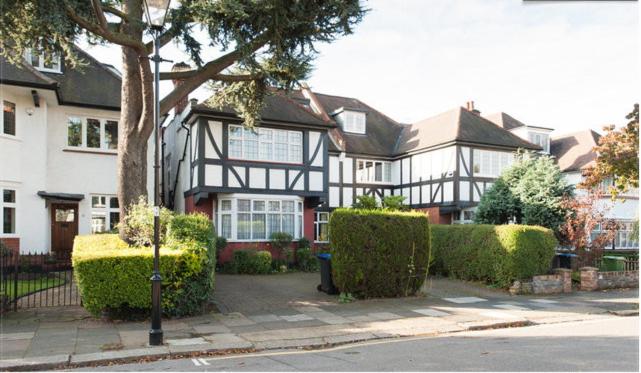 een groot zwart-wit huis met bomen en struiken bij Saint Gabriel's Road Guesthouse in Londen