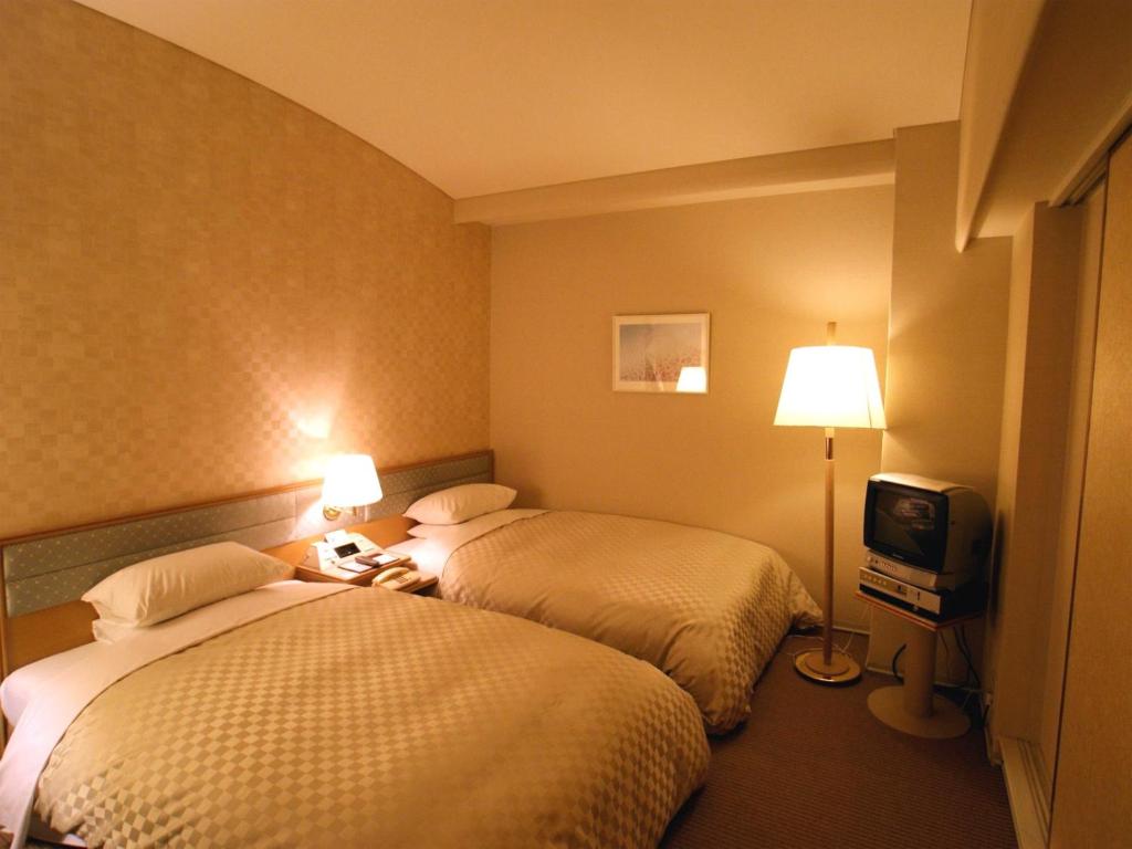 Postel nebo postele na pokoji v ubytování Palace Hotel Kakegawa