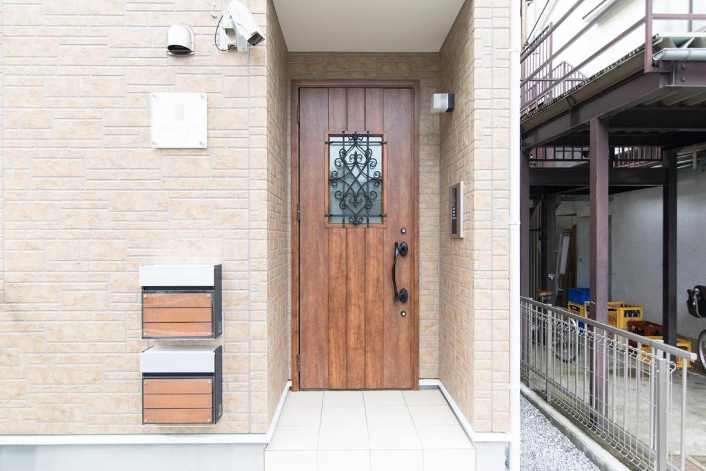 een houten deur aan de zijkant van een gebouw bij RUMa INN Rokugoudote in Tokyo