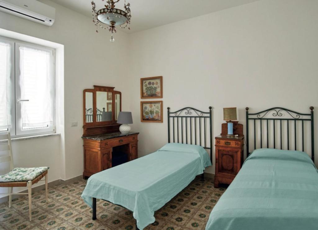 イスキアにあるIl Torrione sul mare M2のベッドルーム1室(ベッド2台、ドレッサー、窓付)