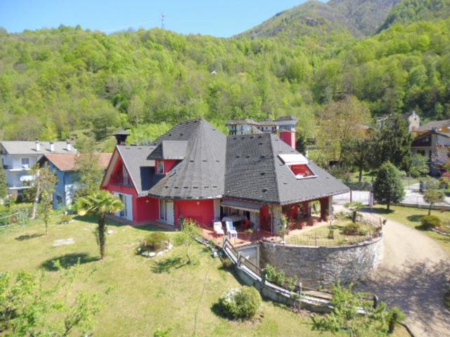uma casa vermelha com um telhado preto numa colina em A casa di Lara em Beura
