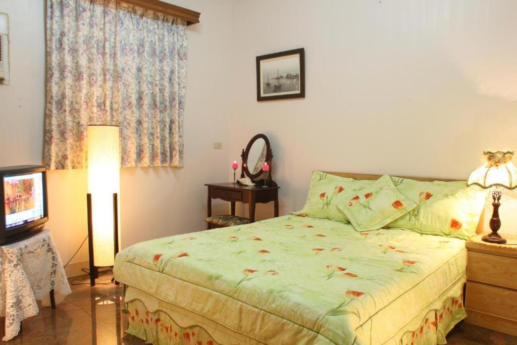 a bedroom with a bed and a lamp and a television at Yilan Affectivity in Wujie