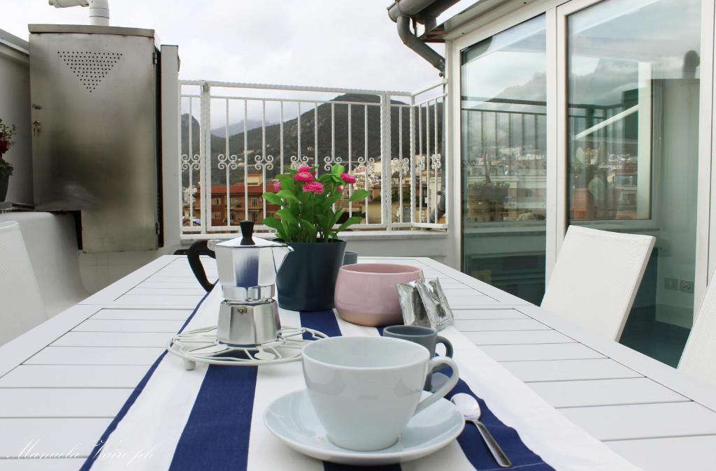 a table with a coffee maker and cups on a balcony at La Casa di MaPi in Salerno