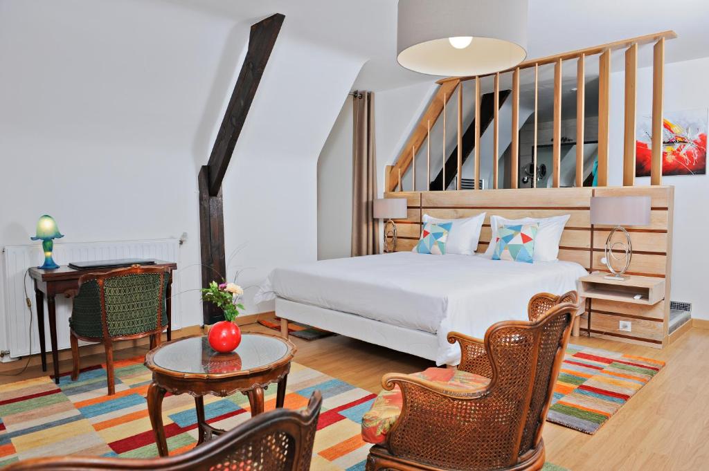 um quarto com uma cama, uma mesa e cadeiras em La noyeraie du port d'enveaux em Saint-Vincent-de-Cosse