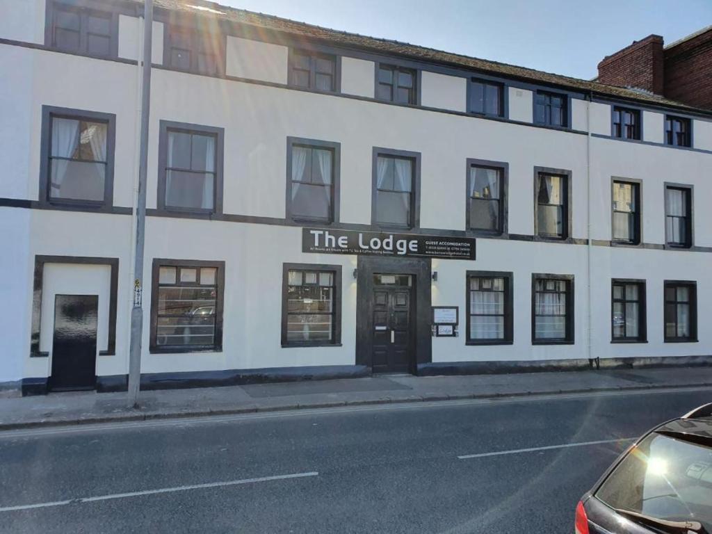 un edificio blanco al lado de una calle en The Lodge Guest Accommodation, en Barrow-in-Furness