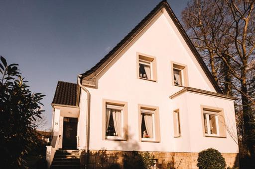 duży biały dom z dwoma oknami i drzwiami w obiekcie Ferienwohnung am Berg w mieście Lengerich