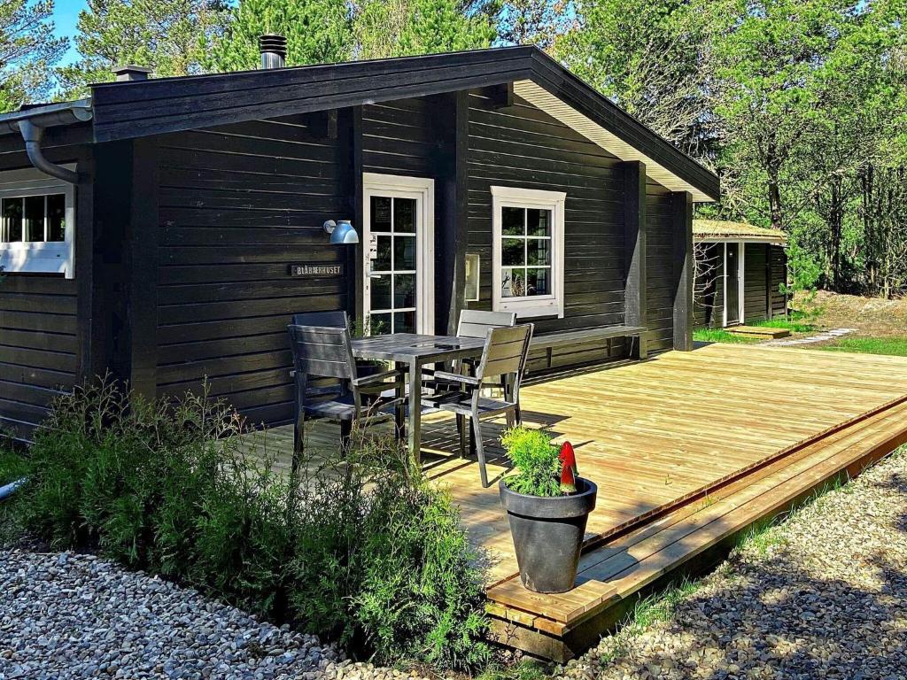 a cabin with a table and chairs on a wooden deck at Three-Bedroom Holiday home in Rømø 9 in Bolilmark