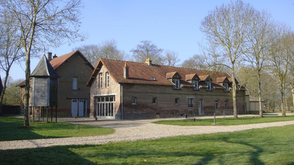 a large brick building with a gambrel roof at Chambres d’Hôtes La Chance au Roy in Aigneville