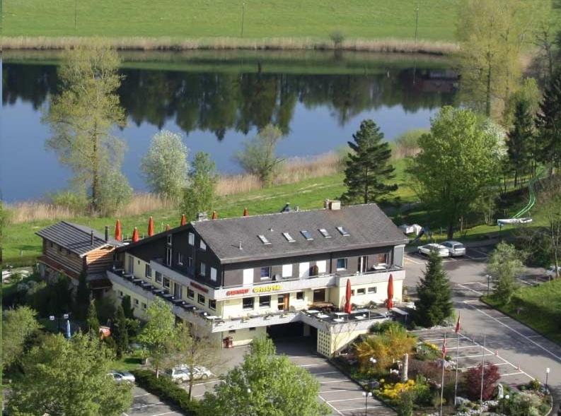 an aerial view of a large building next to a lake at Erlebnisland Grizzlybär in Längenbühl 