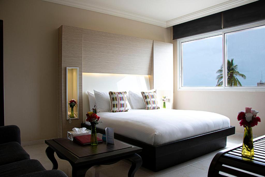 フリータウンにあるHome Suites Boutique Hotel Freetownのベッドと窓のあるホテルの部屋