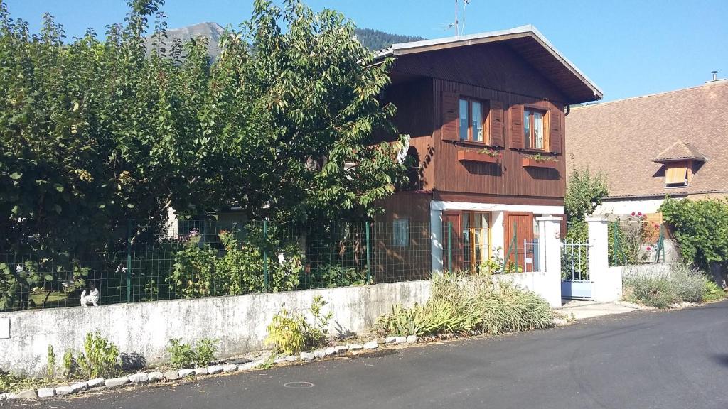 a house with a fence on the side of a street at Chalet dans village in Saint-Maurice-en-Trièves