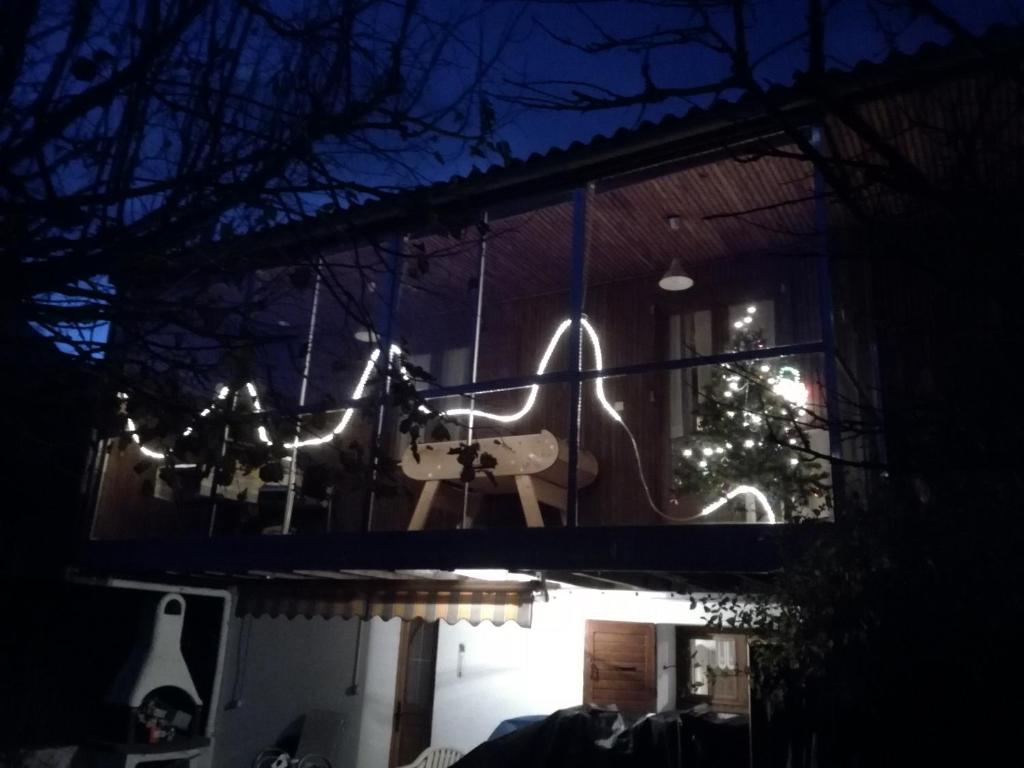 a house with a guitar and a christmas tree in the dark at Chalet dans village in Saint-Maurice-en-Trièves