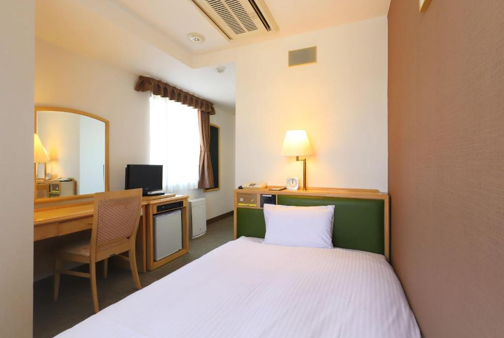 Cette chambre comprend un lit, un bureau et un ordinateur. dans l'établissement Smile Hotel Nagoya Shinkansenguchi, à Nagoya