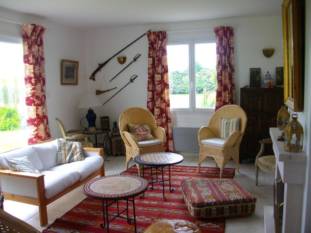a living room with a couch and chairs at Maison d'Aude in Brignogan-Plage