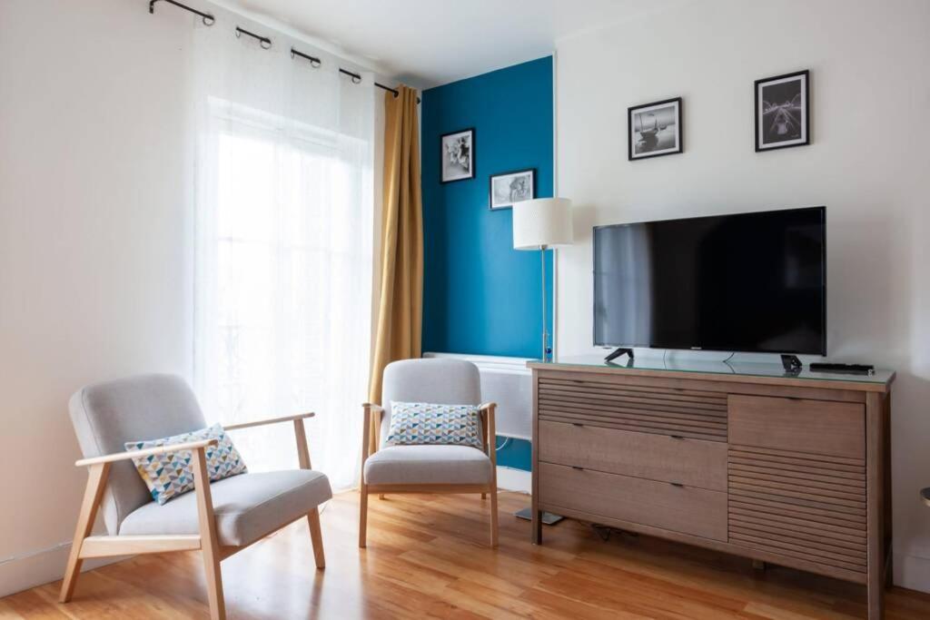 uma sala de estar com televisão e duas cadeiras em Magnifique studio avec Balcon-Vieux Port-Panier em Marselha