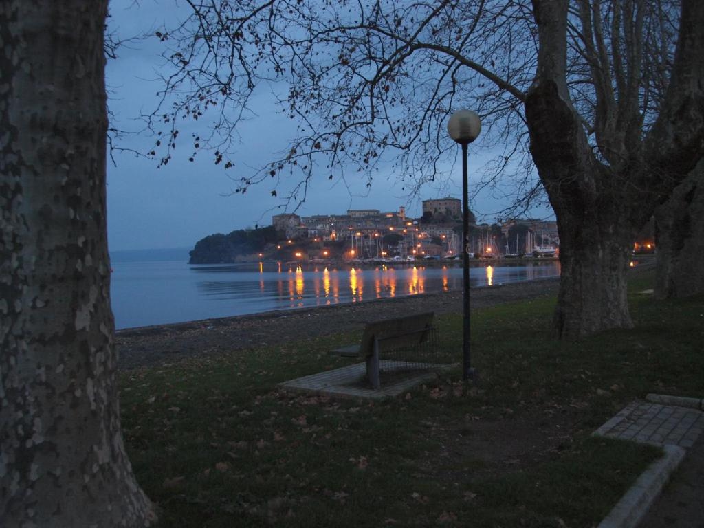 un banco del parque con vistas al agua por la noche en La Baia del Lago, en Marta