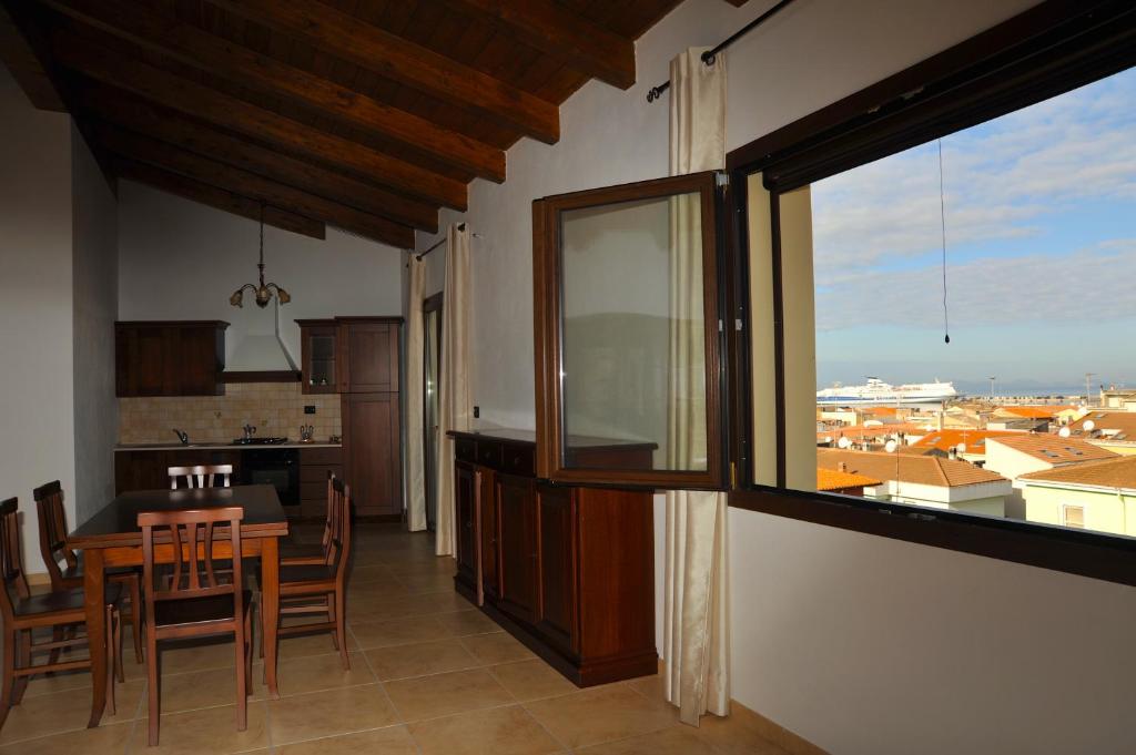 una cucina e una sala da pranzo con tavolo e finestra di B&B L'Ancora a Porto Torres