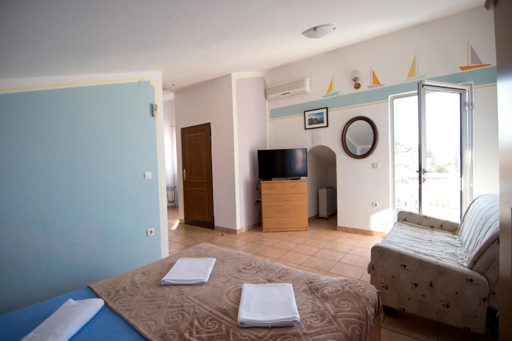Televízia a/alebo spoločenská miestnosť v ubytovaní Apartmani Jurić
