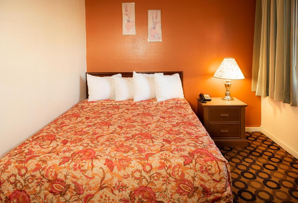 una camera d'albergo con letto e lampada di Granada Inn a Santa Clara
