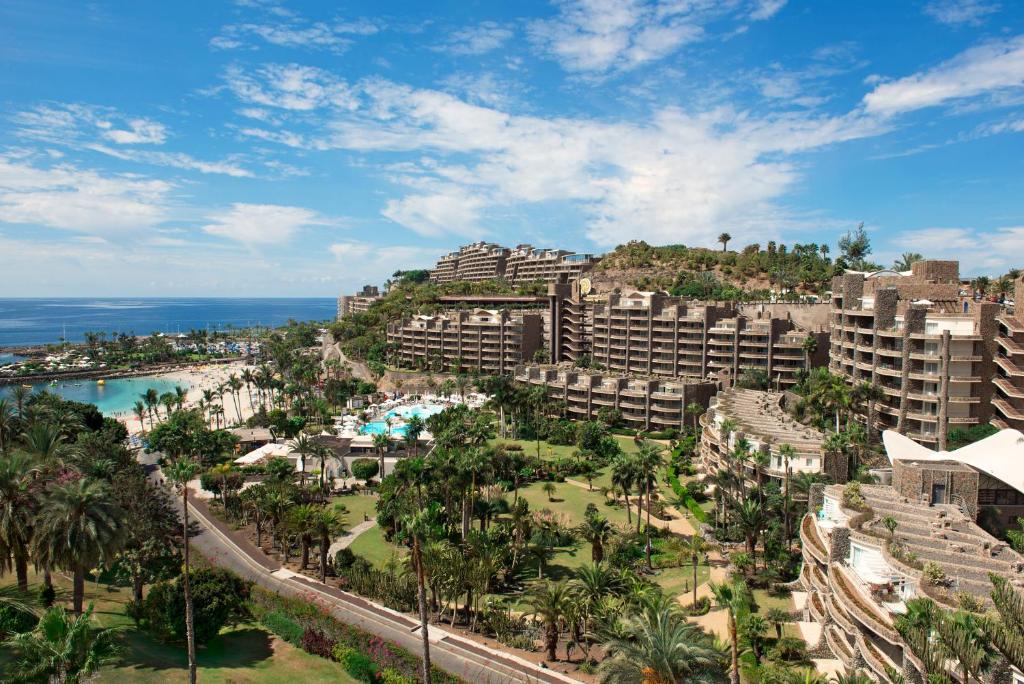 einen Luftblick auf ein Resort mit Palmen und dem Meer in der Unterkunft Anfi del Mar 2 in La Playa de Arguineguín