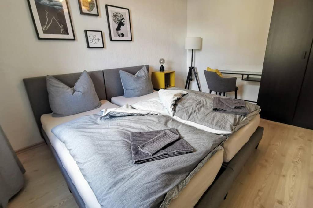 een groot bed in een slaapkamer met kussens erop bij Stylish 4ZI Netflix, Kaffeetimer, WIFI, Parken in Brand-Erbisdorf