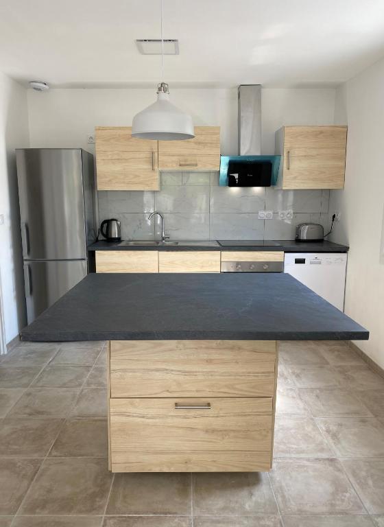 a kitchen with wooden cabinets and a counter top at Maison calme à Beaune in Beaune