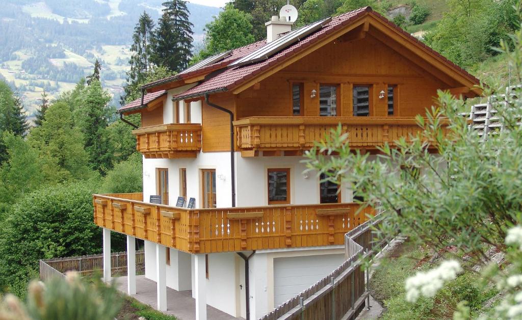 ein Haus mit einer Holzveranda und einer Garage in der Unterkunft Ferienhaus Enterberg in Ramsau im Zillertal