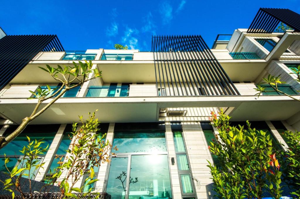 ein hohes weißes Gebäude mit Fenstern und Bäumen in der Unterkunft MIKE B&B in Wujie