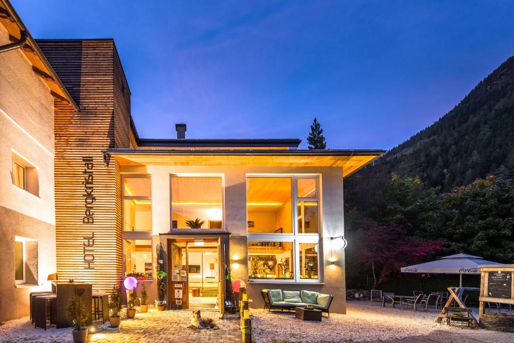 une maison avec une grande porte en verre devant elle dans l'établissement Hotel Bergkristall, à Mallnitz