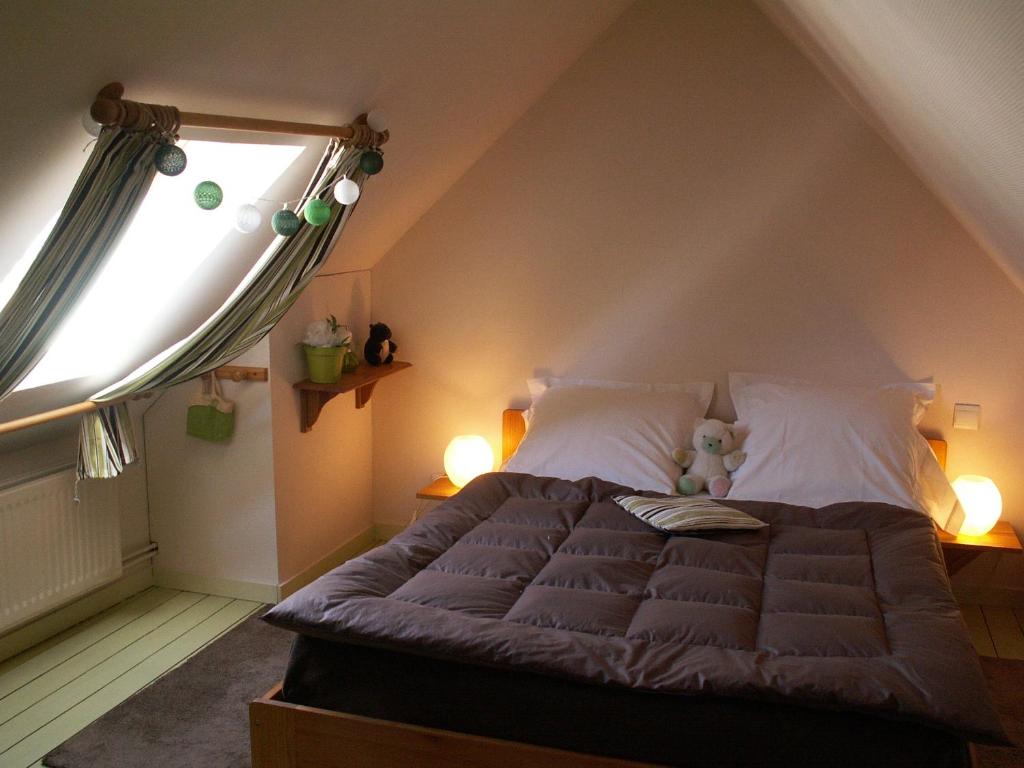 a bedroom with a large bed with a window at Chambre d&#39;hôtes - Dodo et tartines in Bayeux