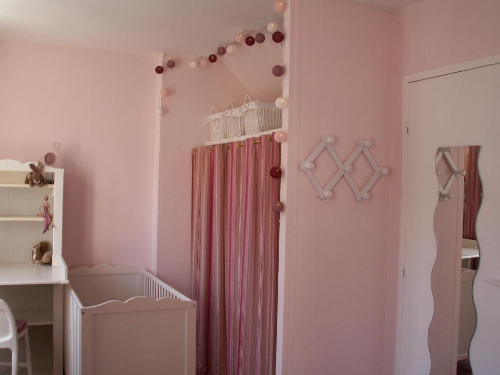 a pink nursery with a shower curtain and a crib at Chambre d&#39;hôtes - Dodo et tartines in Bayeux