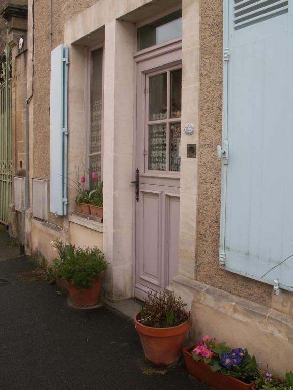 a door of a building with potted plants on the sidewalk at Chambre d&#39;hôtes - Dodo et tartines in Bayeux