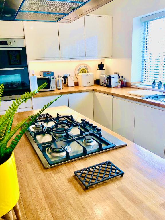a stove top oven sitting on a wooden table in a kitchen at The Duplex Margate with Deck & Living Space Air Conditioning in Margate
