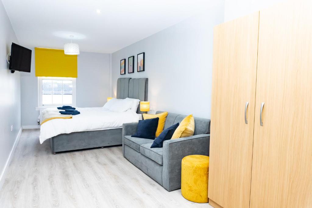 een slaapkamer met een bank en een bed erin bij Spa Court in Cheltenham