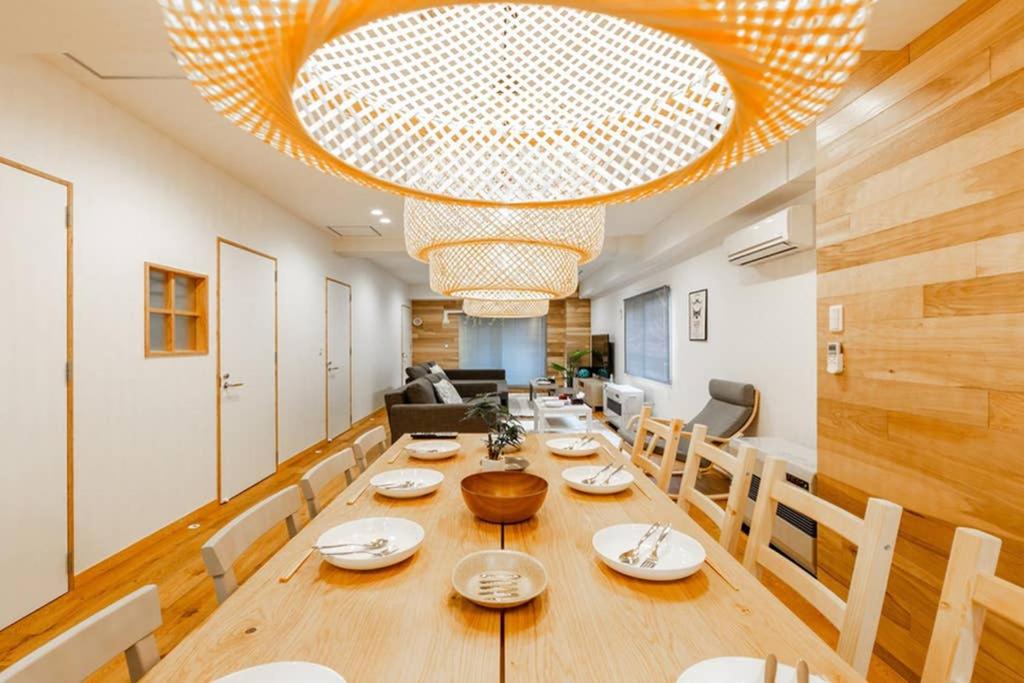 a dining room with a table and a large chandelier at THE EAST AVENUE in Sapporo