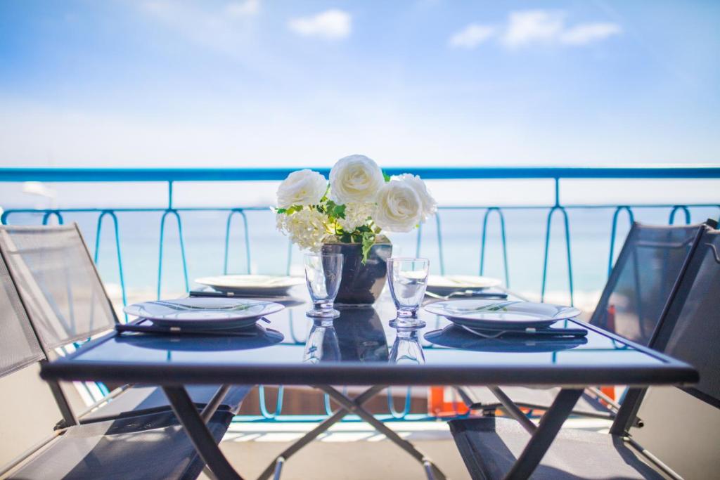 ジュアン・レ・パンにあるFront de Mer vue panoramique PARKING SECURISEの船上の皿と花のテーブル