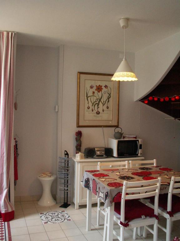 a kitchen with a table with chairs and a microwave at Chambre d&#39;hôtes - Dodo et tartines in Bayeux