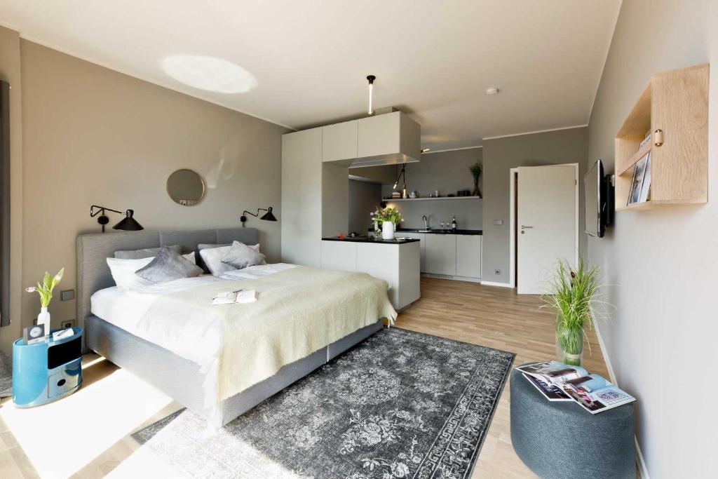 Design-Apartment an der Strandallee nur 50 Meter vom Strand في شاربوتس: غرفة نوم بسرير كبير ومطبخ