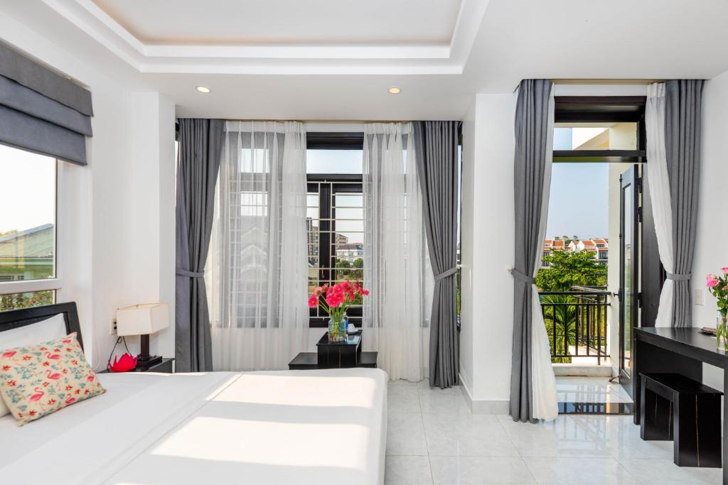 Postel nebo postele na pokoji v ubytování Flamingo Villa Homestay - Big Rooms with Balcony - Close to Hoi An Old Town 200m & Temple Bridge - Large Outside Pool for Sun Bathing