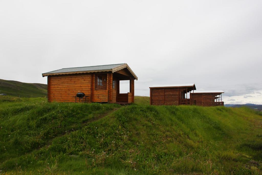 two small buildings on top of a grassy hill at Hlíd Huts in Myvatn