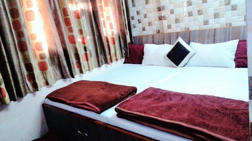 een bed met twee kussens erop bij Ajanta Hotel 100 Mtrs Railway Station & 400 Mtrs Dargah in Ajmer