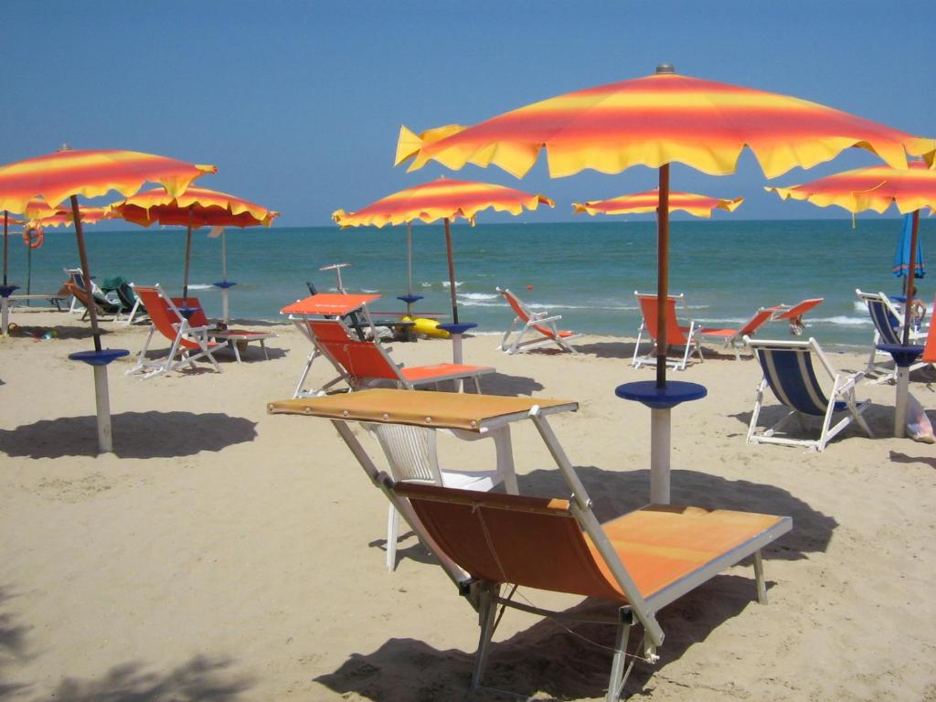 a group of chairs and umbrellas on a beach at Victoria mobilehome in Village Residence Juliamare in Giulianova