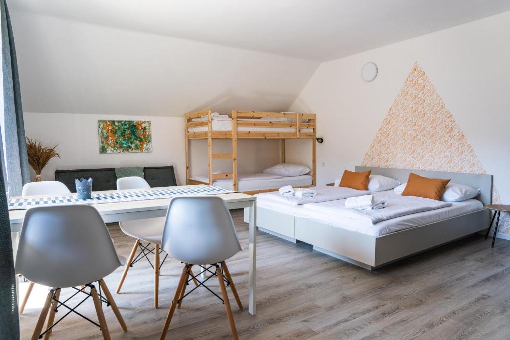 een woonkamer met een bank en een tafel en stoelen bij Apartmaji Triglav in Bohinj