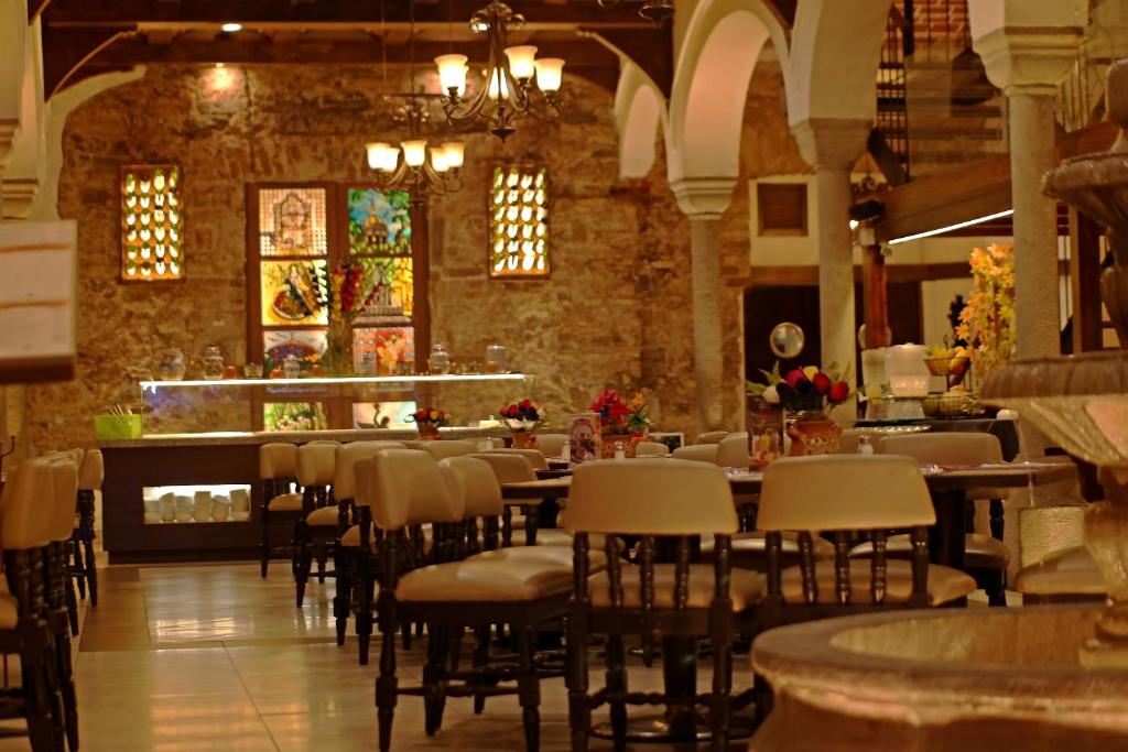 um restaurante com mesas e cadeiras e um bar em Hotel Del Portal, Puebla em Puebla