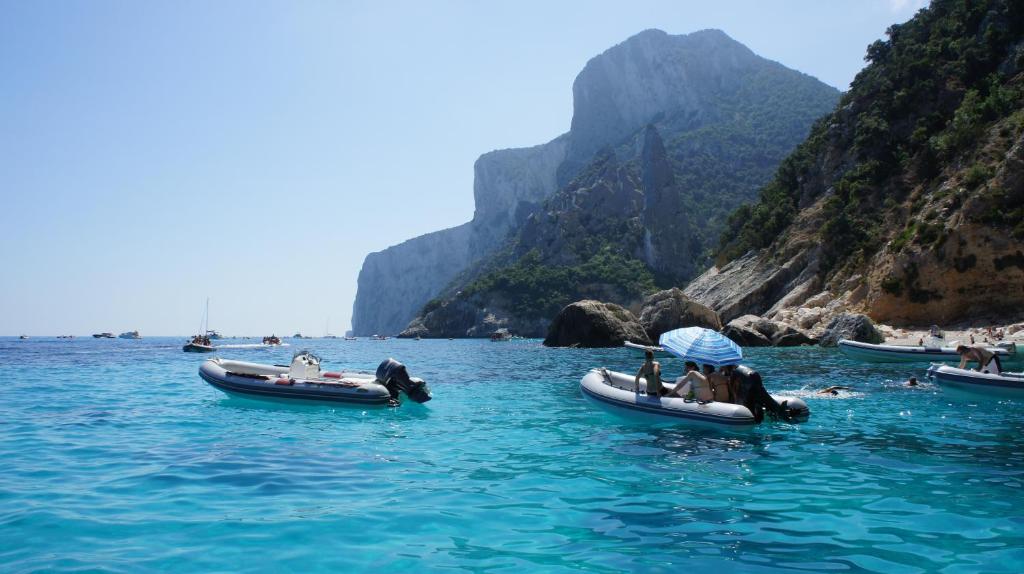 a group of people in boats in the water at Casa Turusele in Santa Maria Navarrese