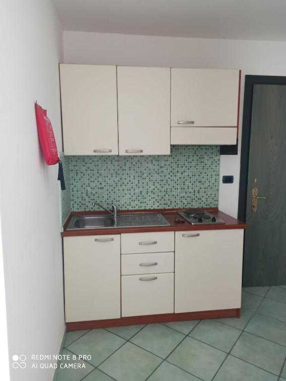 a kitchen with white cabinets and a sink at La Residenza Aparthotel in Maiori